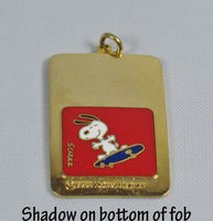 Snoopy Cloisonne Pendant / Key Fob - Skateboarder  (Shadow On Bottom of Pendant In Photo)